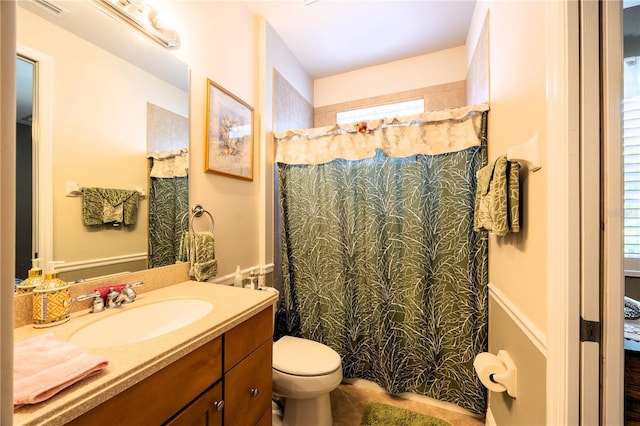 bathroom featuring vanity, tile patterned flooring, toilet, and walk in shower