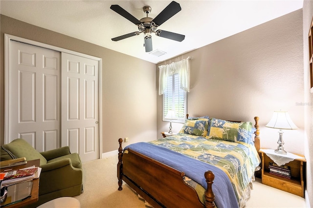 carpeted bedroom with ceiling fan and a closet