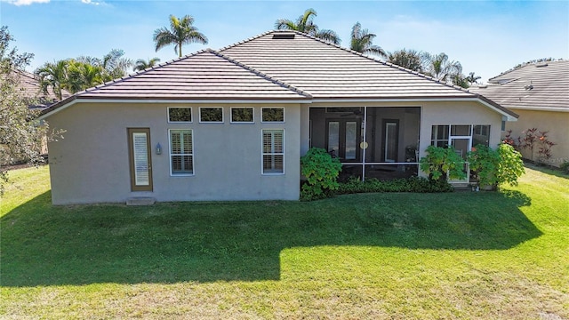 back of house with a sunroom and a lawn