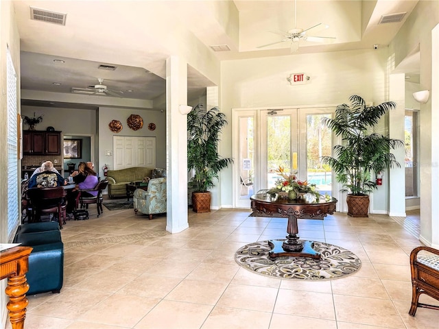 foyer featuring a high ceiling, light tile patterned floors, and ceiling fan