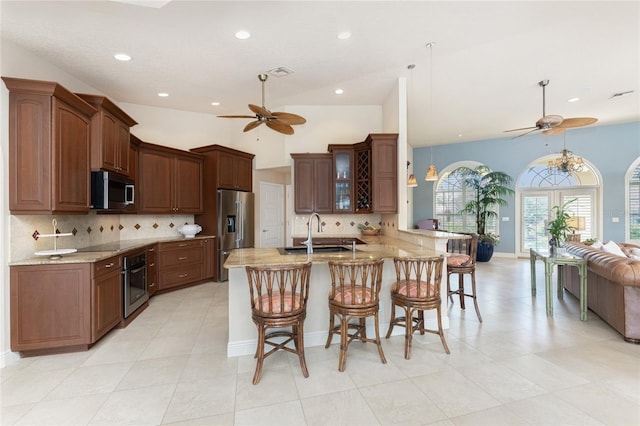 kitchen with appliances with stainless steel finishes, sink, a breakfast bar, and kitchen peninsula