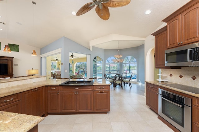 kitchen with pendant lighting, sink, stainless steel appliances, tasteful backsplash, and vaulted ceiling