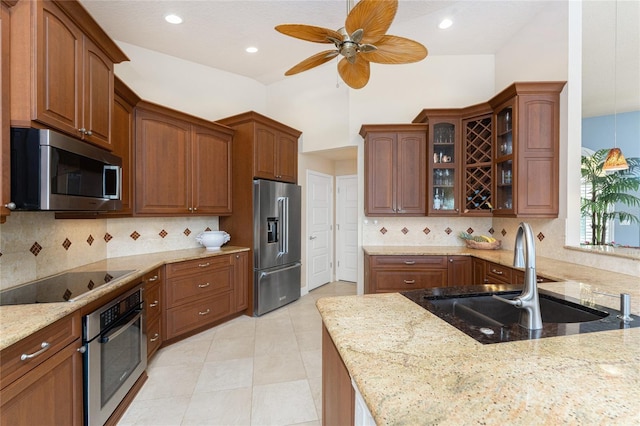 kitchen featuring sink, decorative backsplash, light stone countertops, and appliances with stainless steel finishes