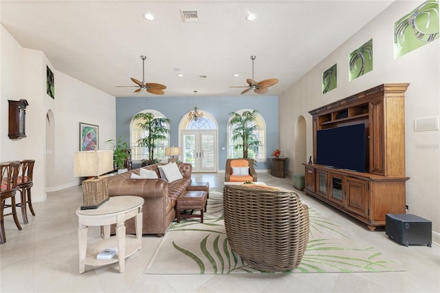 tiled living room featuring ceiling fan and french doors