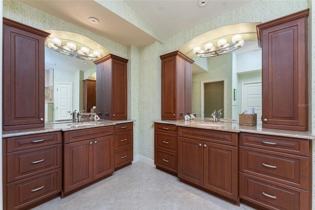 bathroom with ornate columns, tile patterned floors, vanity, and a notable chandelier