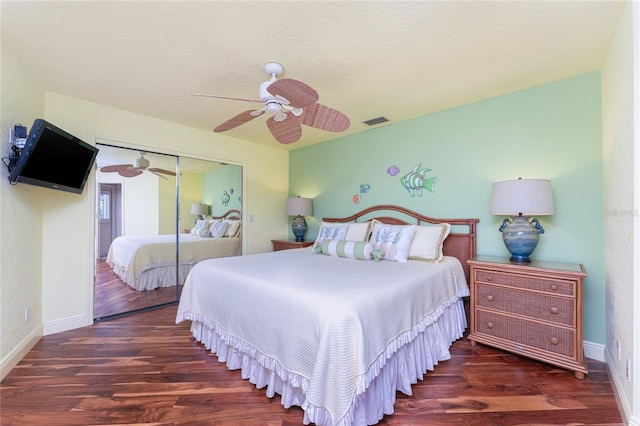 bedroom with dark hardwood / wood-style floors, a textured ceiling, ceiling fan, and a closet