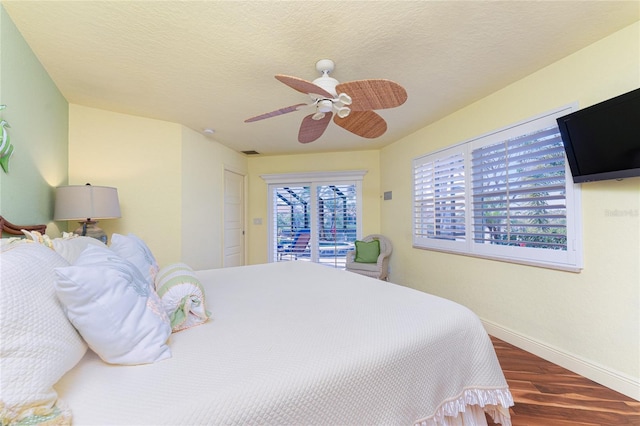 bedroom featuring ceiling fan, dark hardwood / wood-style flooring, a textured ceiling, and access to outside