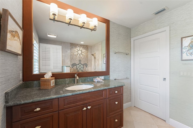 bathroom with tile patterned flooring, vanity, and walk in shower