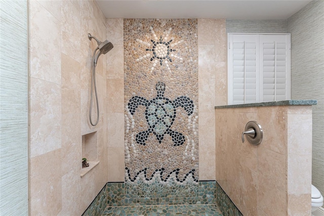 bathroom featuring a tile shower and toilet