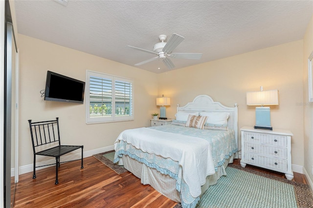 bedroom with ceiling fan, dark hardwood / wood-style floors, and a textured ceiling