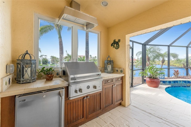 view of patio with a water view, an outdoor kitchen, grilling area, and a lanai