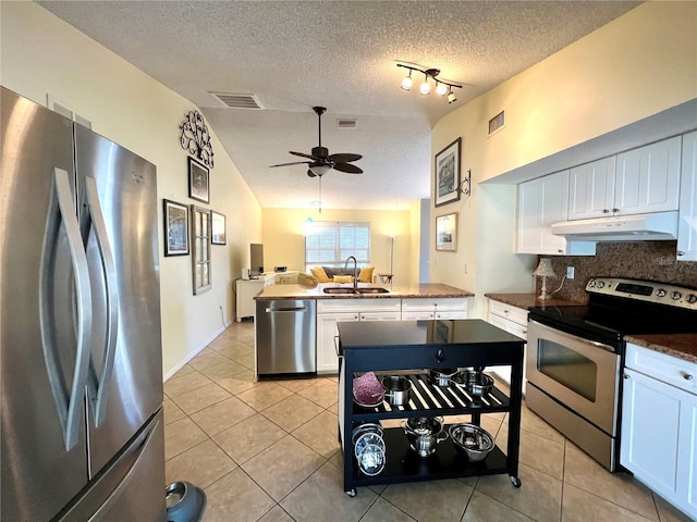 kitchen with sink, tasteful backsplash, light tile patterned floors, stainless steel appliances, and white cabinets