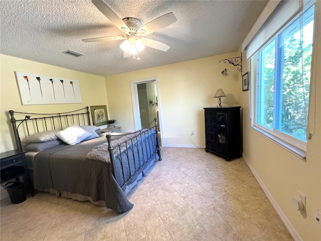 bedroom with ceiling fan and a textured ceiling