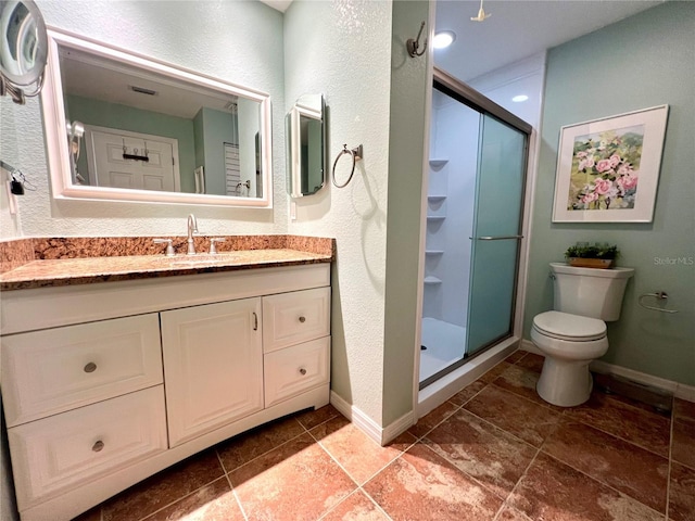 bathroom with vanity, a shower with shower door, and toilet