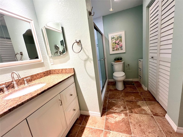 bathroom with vanity, toilet, and a shower with shower door