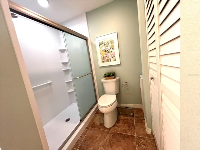 bathroom with a shower with shower door and toilet