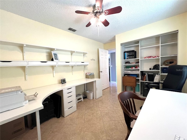 tiled home office with ceiling fan and a textured ceiling