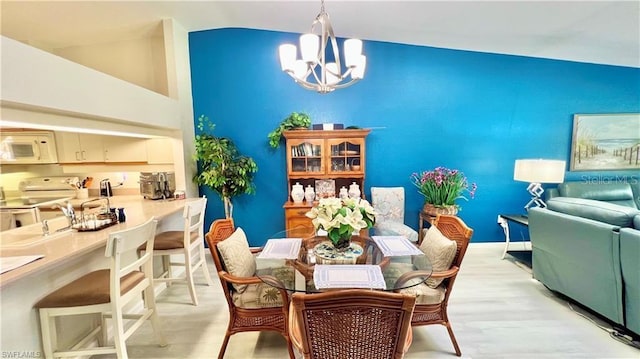 dining area featuring vaulted ceiling and a chandelier