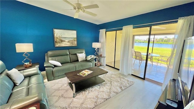 living room featuring vaulted ceiling, a water view, and ceiling fan