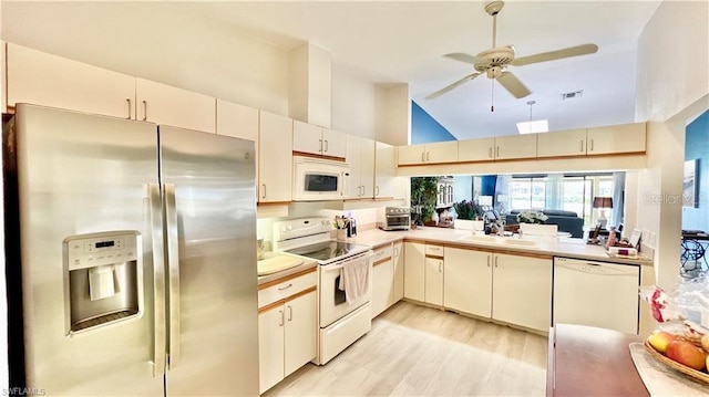 kitchen featuring high vaulted ceiling, white appliances, ceiling fan, light wood-type flooring, and cream cabinetry