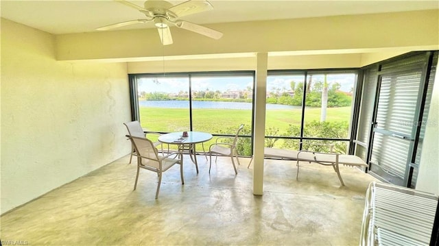 sunroom / solarium featuring a water view and ceiling fan