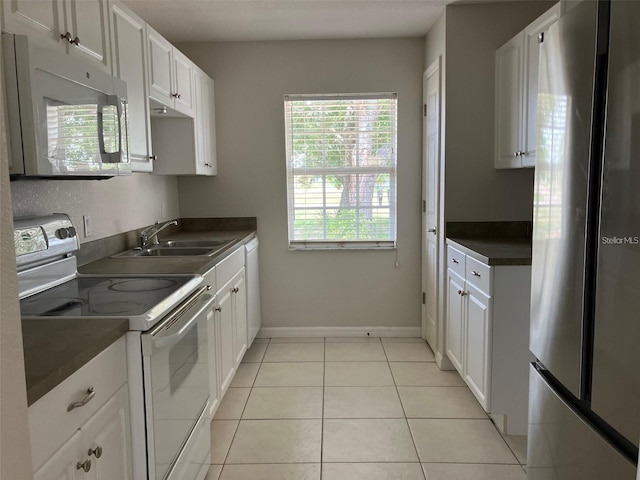 kitchen with white appliances, light tile patterned floors, sink, and white cabinets