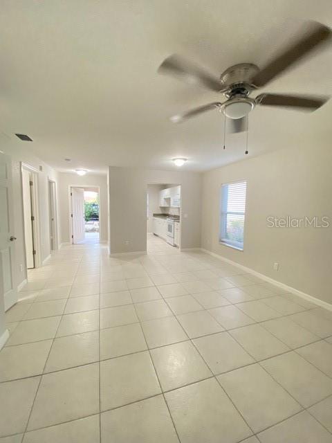 tiled spare room with ceiling fan