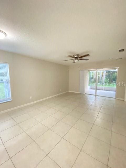 unfurnished room with ceiling fan and light tile patterned floors