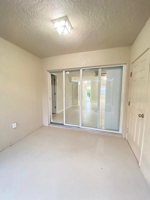 unfurnished room with a textured ceiling