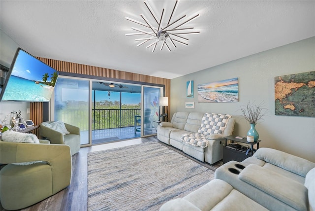 living room featuring a chandelier, hardwood / wood-style floors, and a textured ceiling