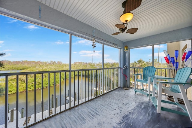 sunroom / solarium featuring ceiling fan and a water view