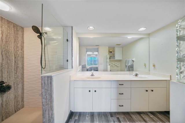 bathroom featuring hardwood / wood-style flooring, vanity, and a tile shower