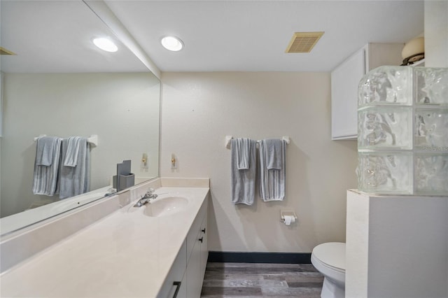 bathroom with vanity, toilet, and wood-type flooring