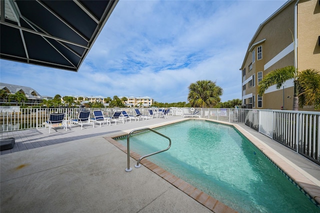 view of pool featuring a patio and a water view