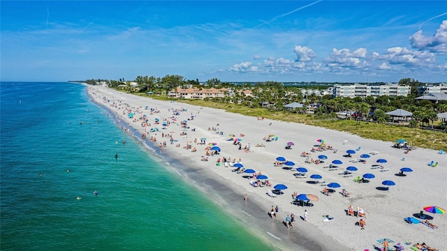 drone / aerial view with a water view and a beach view