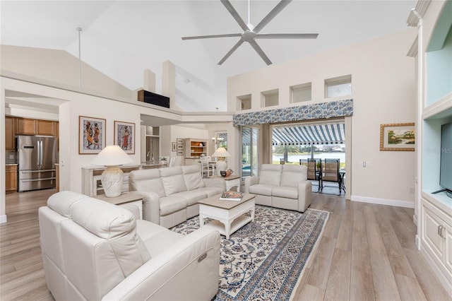 living room featuring ceiling fan, high vaulted ceiling, and light wood-type flooring