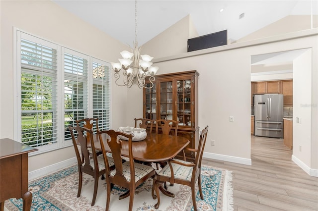 dining room featuring an inviting chandelier, lofted ceiling, and light hardwood / wood-style floors