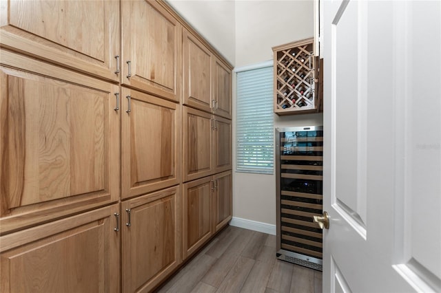 interior space featuring indoor bar, wine cooler, and light wood-type flooring