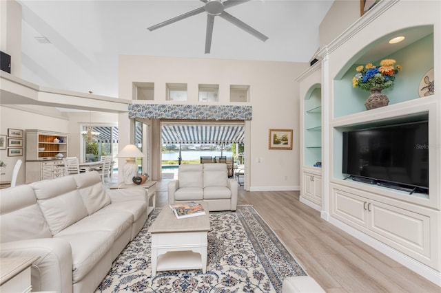 living room featuring ceiling fan, a healthy amount of sunlight, built in features, and light hardwood / wood-style floors