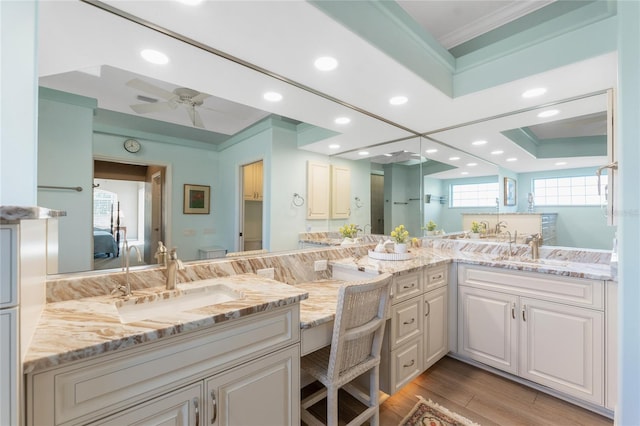 bathroom with vanity, hardwood / wood-style floors, ornamental molding, and ceiling fan