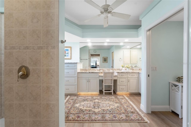 bathroom featuring vanity, hardwood / wood-style floors, crown molding, and ceiling fan