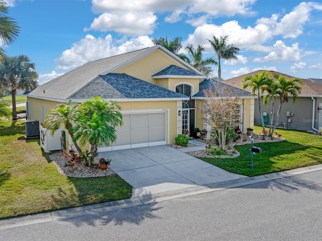 ranch-style house featuring a garage, a front yard, and central AC unit