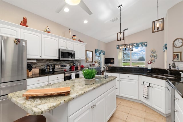 kitchen featuring white cabinetry, stainless steel appliances, and dark stone countertops