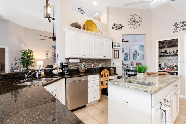 kitchen featuring sink, dishwasher, ceiling fan, white cabinetry, and dark stone counters