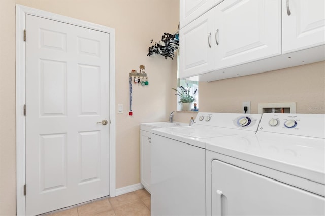 laundry area featuring cabinets, independent washer and dryer, sink, and light tile patterned floors