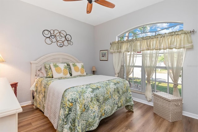 bedroom featuring multiple windows, hardwood / wood-style floors, and ceiling fan