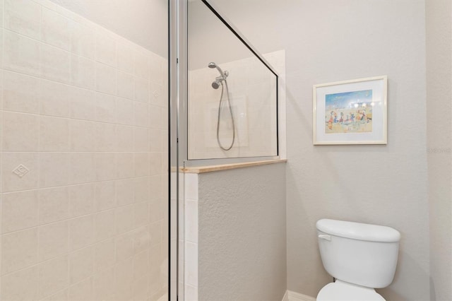 bathroom with toilet and tiled shower