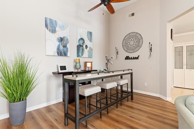 bar featuring ceiling fan and hardwood / wood-style floors