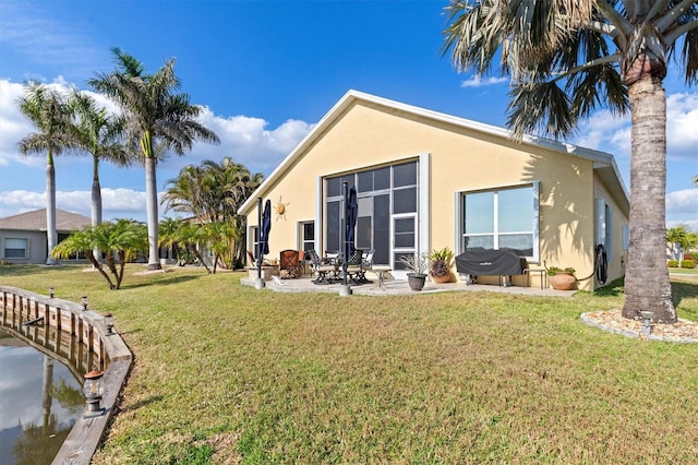 back of property with a yard and a patio area