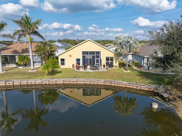 back of property with a yard and a water view